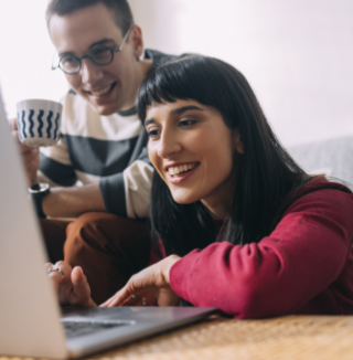 two people looking at a laptop happily